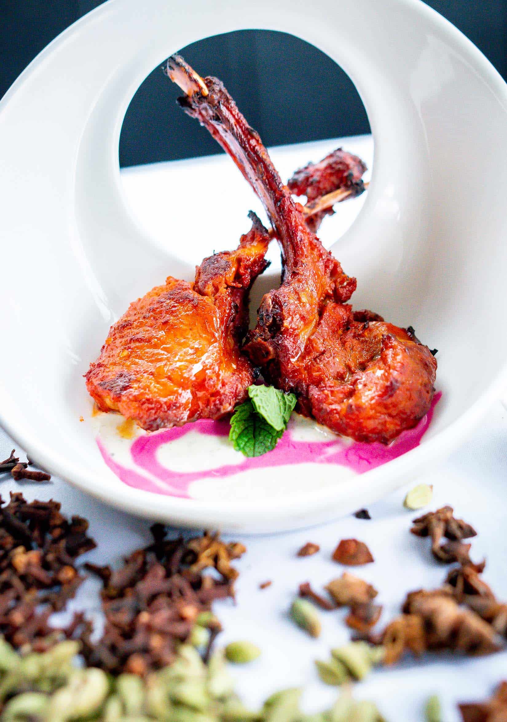 Exquisite presentation of Lamb Cutlets, a specialty dish at Manjits, artistically plated to emphasize the rich flavors and textures unique to this Indian culinary delight